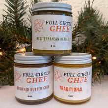 Load image into Gallery viewer, Three jars of Full Circle Ghee with labels on a white surface with a Christmas tree background.
